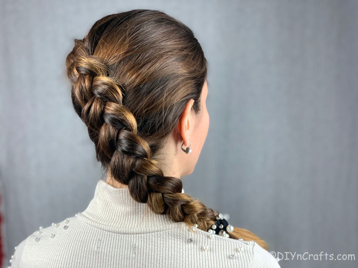 dutch side braid hanging over shoulder of brunette wearing white shirt