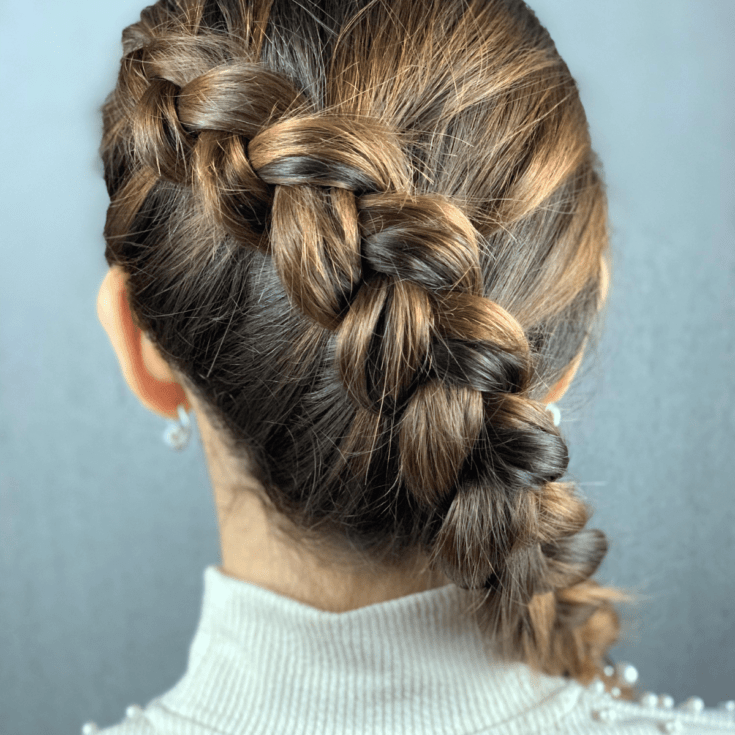 woman in white with side dutch braid hanging over shoulder