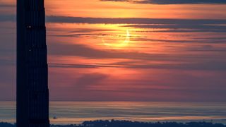 Eclipse solar parcial al amanecer a través de nubes brumosas