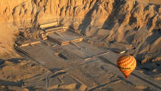 : En una vista aérea, un globo aerostático sobrevuela el templo mortuorio de Hatshepsut a lo largo de Cisjordania el 2 de febrero de 2023 en Luxor, Egipto.