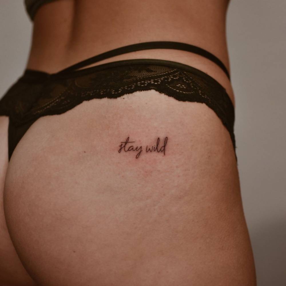 Lettering Tattoo That Says "Stay Wild" Done On The Butt