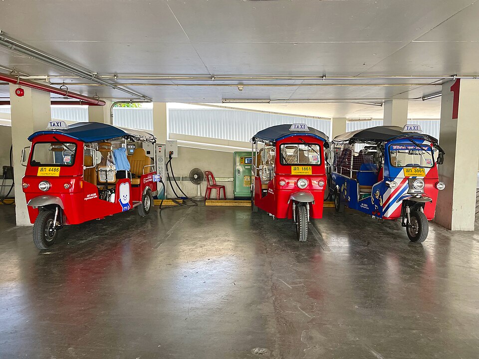 Electric MuvMi tuk-tuks at a charging area in Phaya Thai, Bangkok