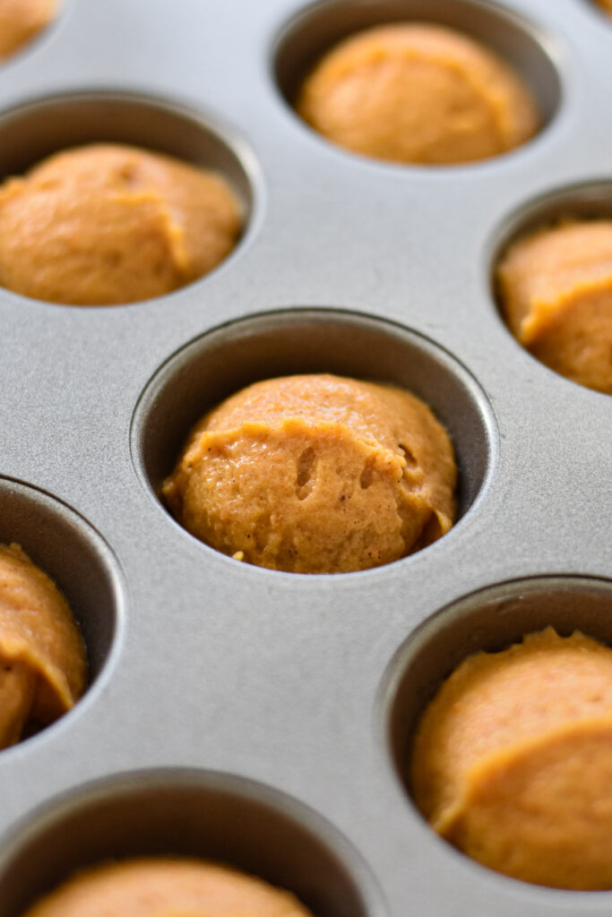 Mini muffin tin with pumpkin muffin batter.