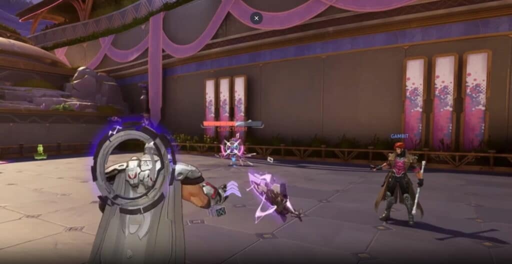 Marvel Rivals scene featuring a futuristic battle. A character aims a weapon at a robotic opponent in a plaza with pink banners