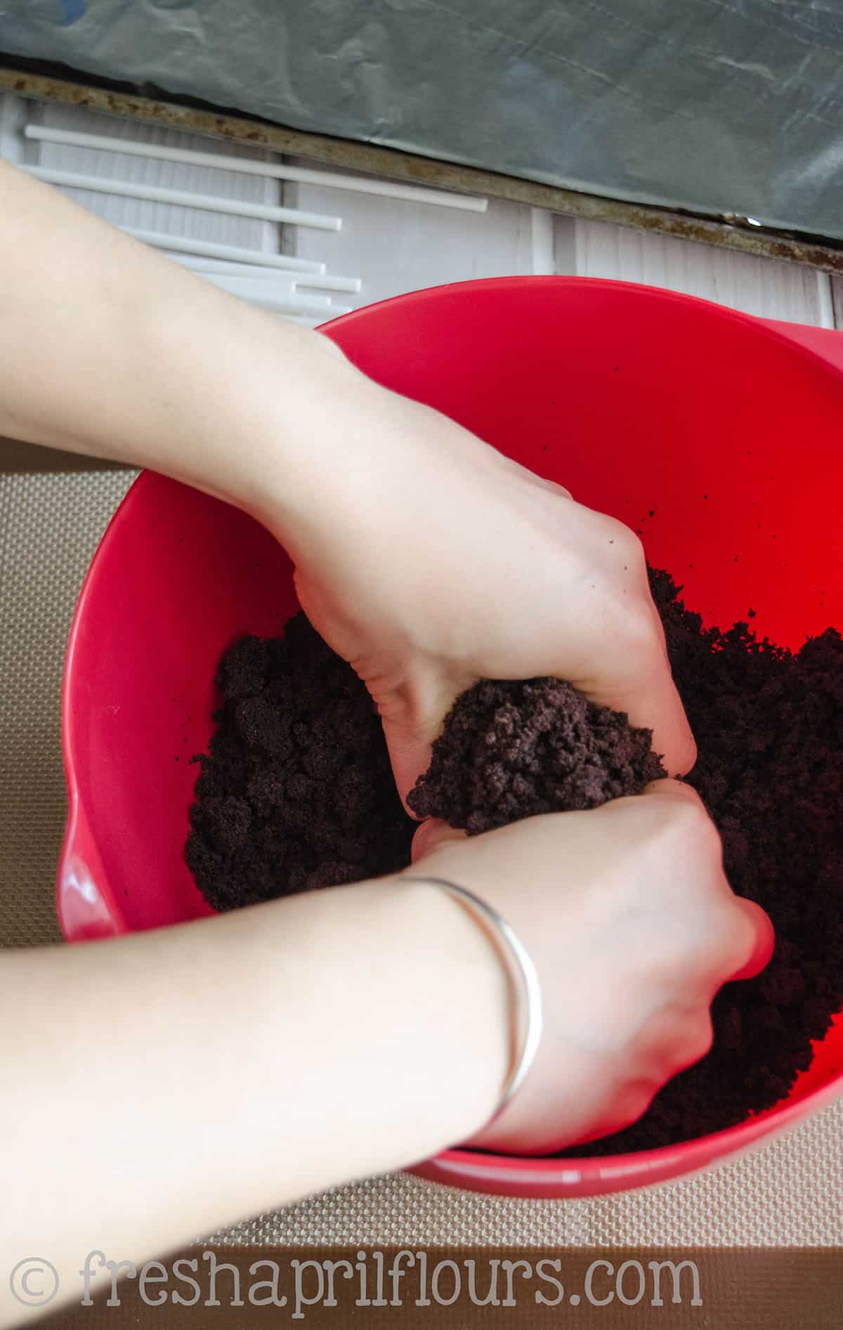 hands crumbling cake to make cake pops