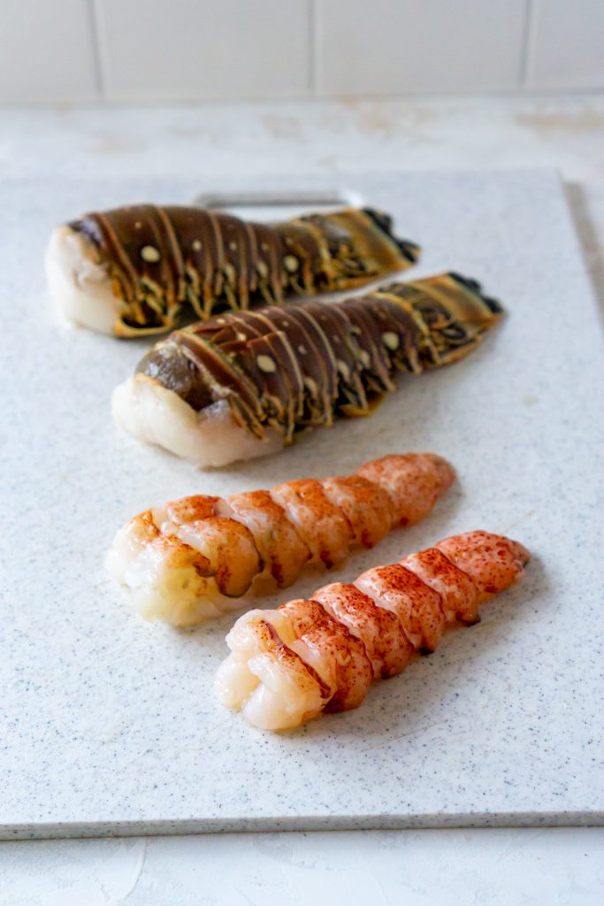 4 lobster tails on a white cutting board