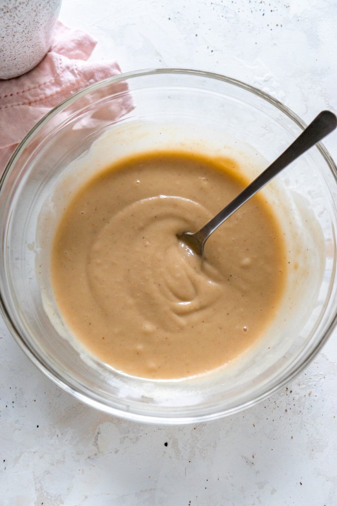mixing tahini sauce in a glass bowl