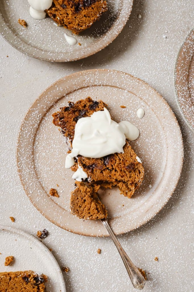 3 plates with a slice of pumpkin bread and icing on top