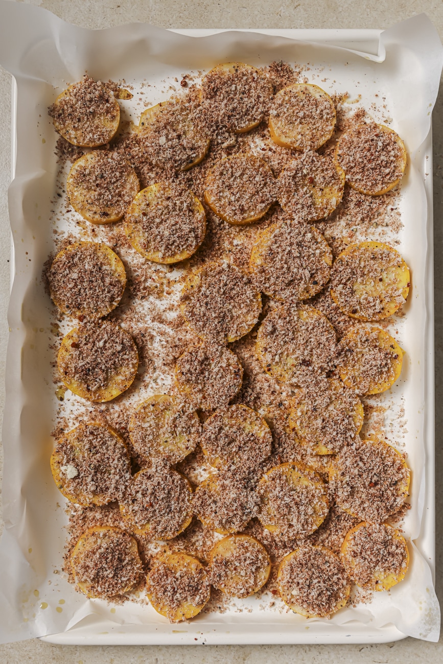 Seasoned yellow squash in a single layer on a prepared baking sheet.