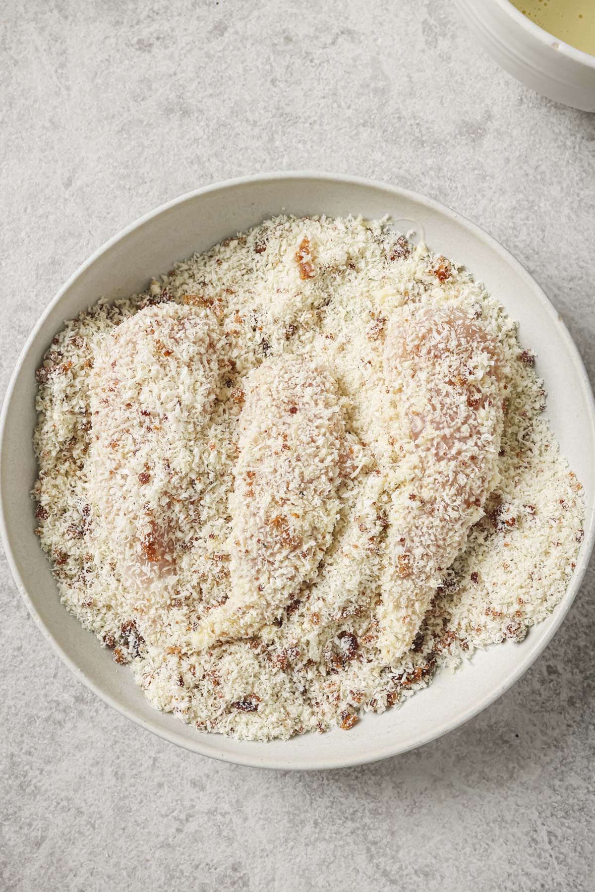 dipping the bacon ranch chicken into the egg, then into the panko mixture