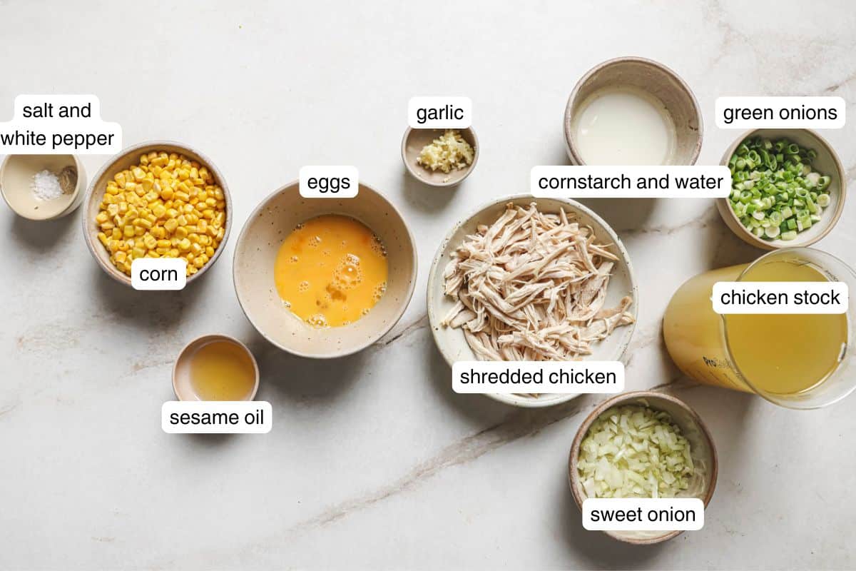 shredded chicken, corn, egg, chicken broth, and green onion in small ingredient bowls.
