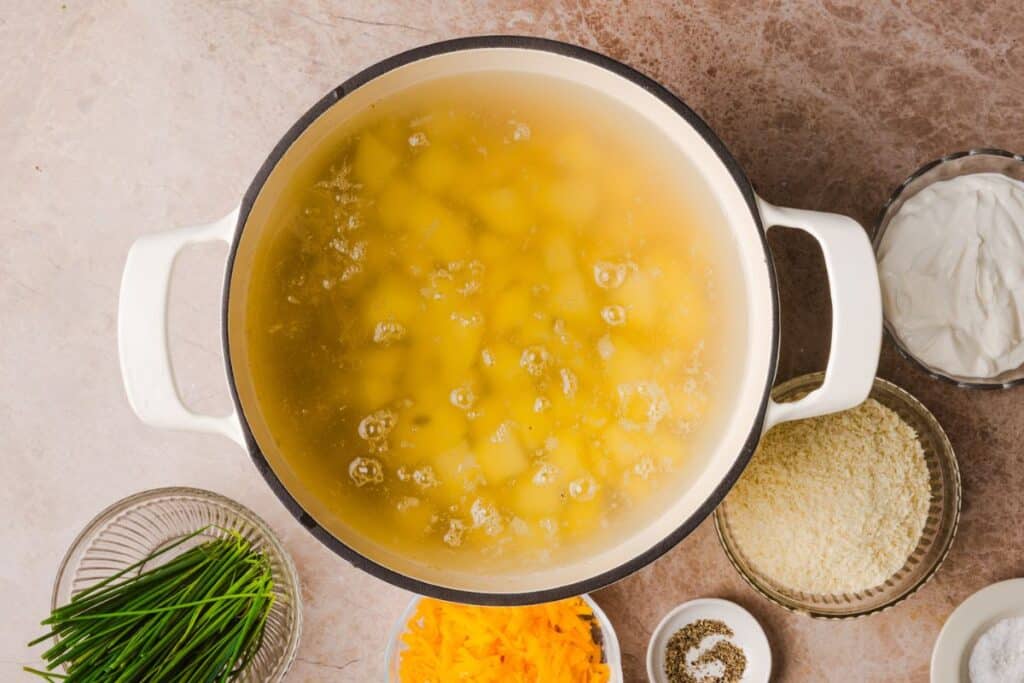 Potatoes boiling in a pot of water.