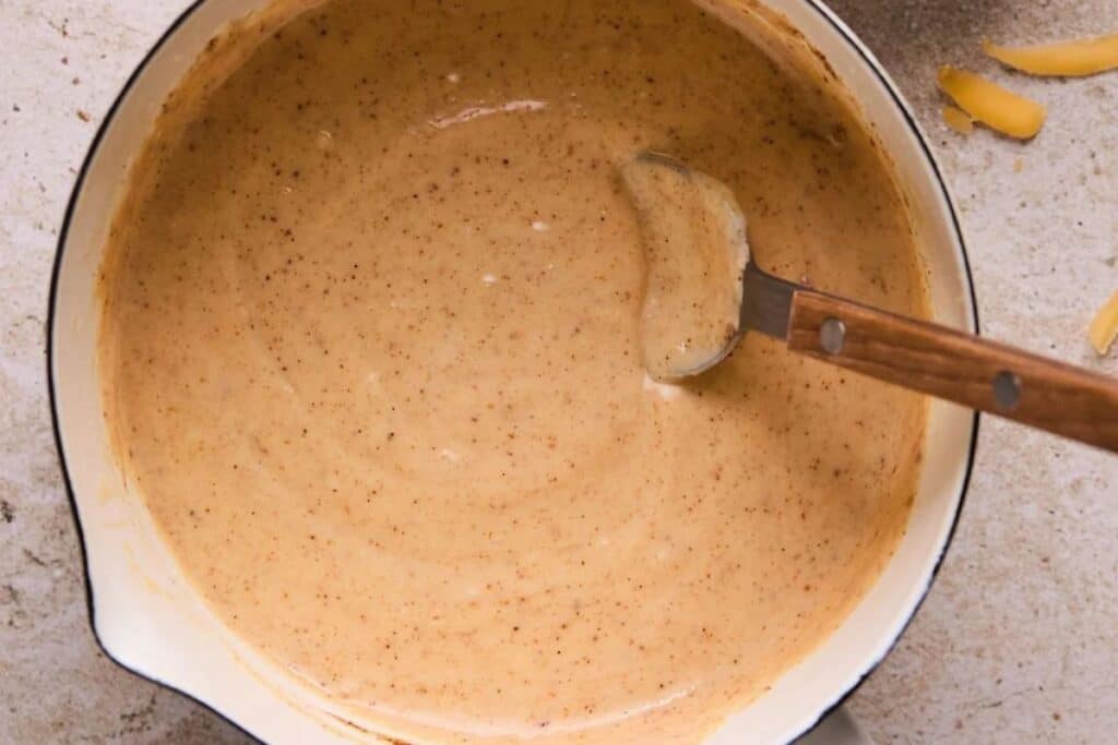 Mixing queso dip in a large pot.