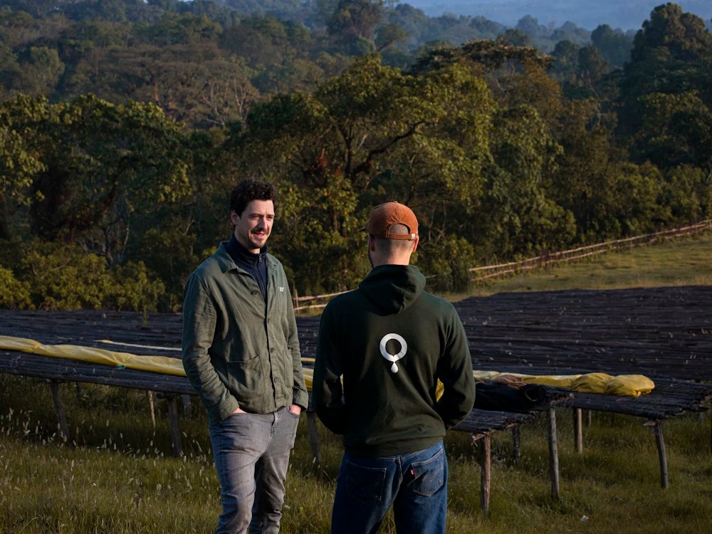 - Healthy Brew Hub Coffee Circle roasters talk by raised beds on a farm.