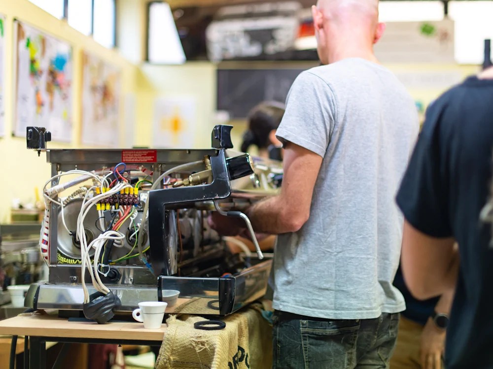 - Healthy Brew Hub A coffee technician fixes an espresso machine.