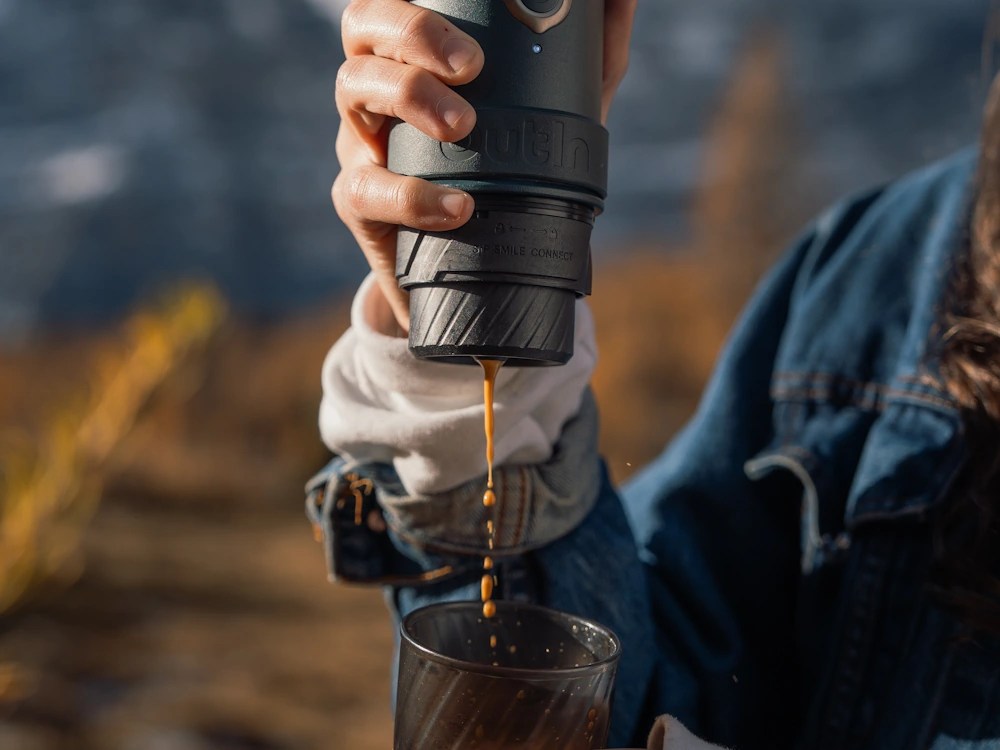 - Healthy Brew Hub A person extracts espresso using an OutIn Mino machine.
