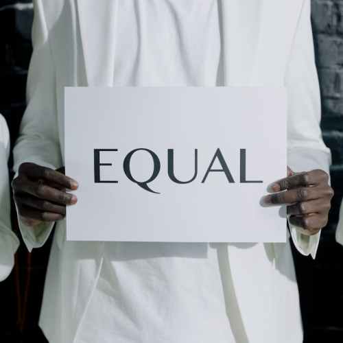 a person holding a paper with a text equal