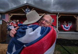 Wrapped in the flag. U.S. Rep. John Rose hugs supporter Natasha Brooks. (Photo:John Partipilo/Tennessee Lookout)