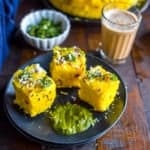 An overhead shot of Nylon Khaman Dhokla served with tea and green chutney