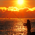 Fisherman Silhouettes and Sunburst View from The Jetty at Sunrise &ldquo;Magic Hour&rdquo; at Barnegat Lighthouse State Park of New Jersey (Long Beach Island)