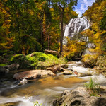 Waterfall in autumn forest National Park, river with waterfall and rocks during autumn