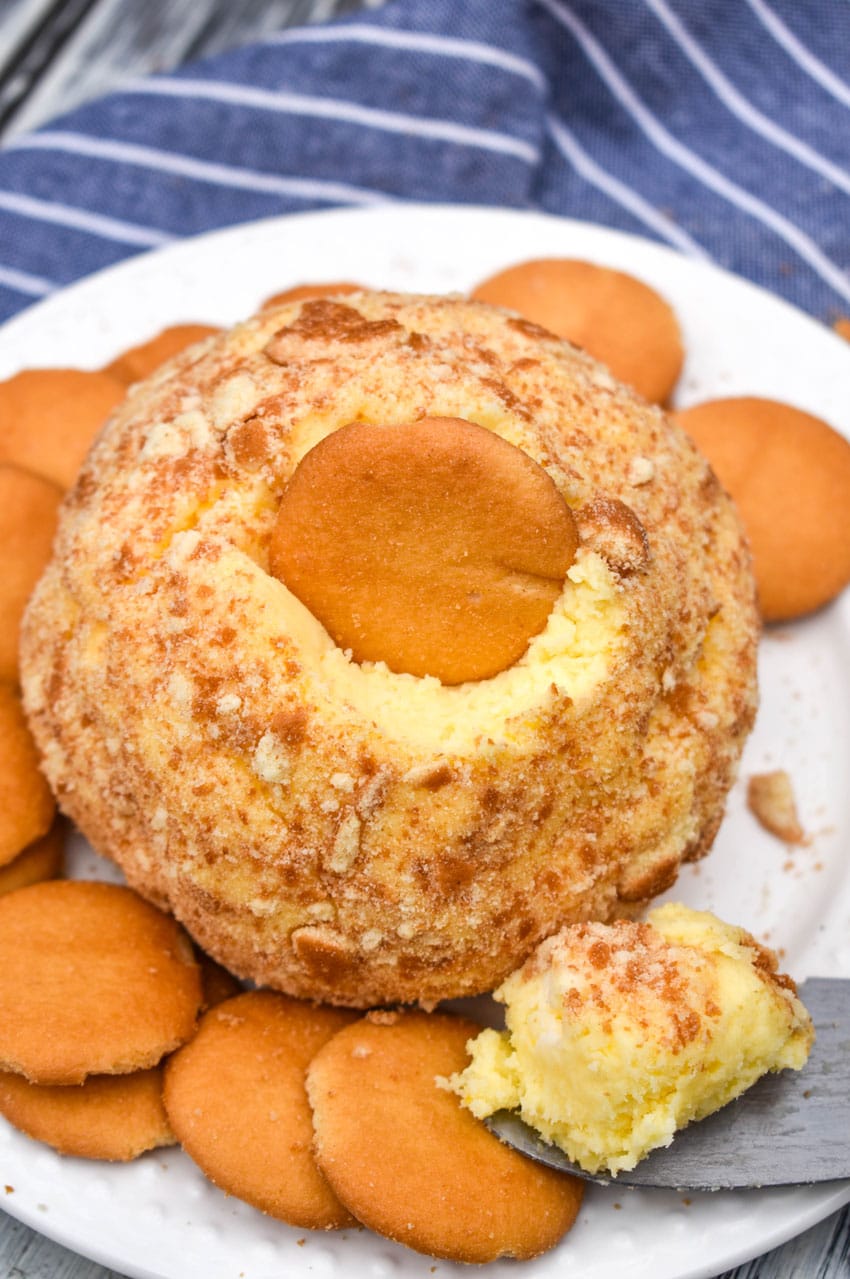 a banana pudding cheese ball surrounded by nilla wafers on a small white plate