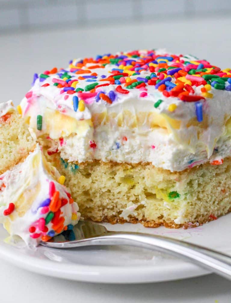 a slice of a layered funfetti cake dessert on a white plate