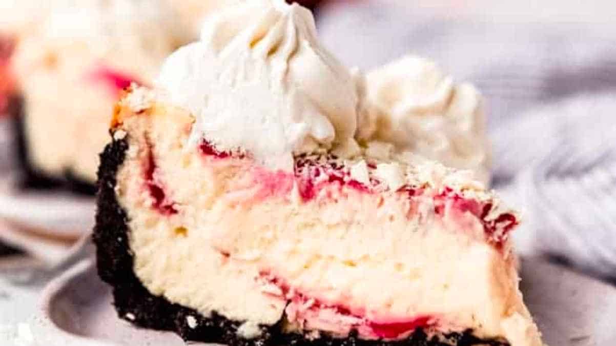 A slice of raspberry cheesecake on a plate.