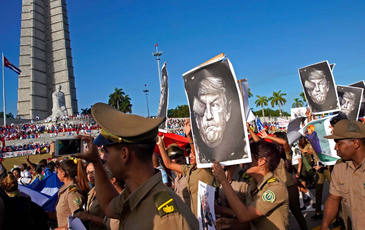 Cuban military personnel carry caricatures of Donald Trump.