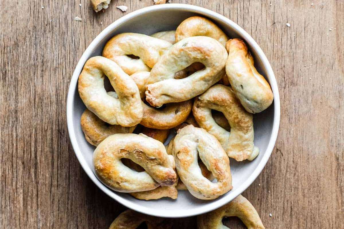 A white bowl of appetizers on a wooden table.