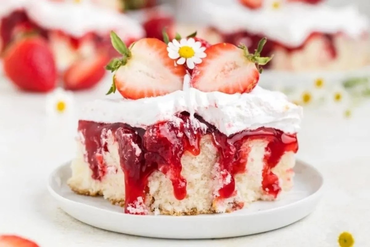 A slice of easy strawberry cake topped with whipped cream and a fresh strawberry garnish.