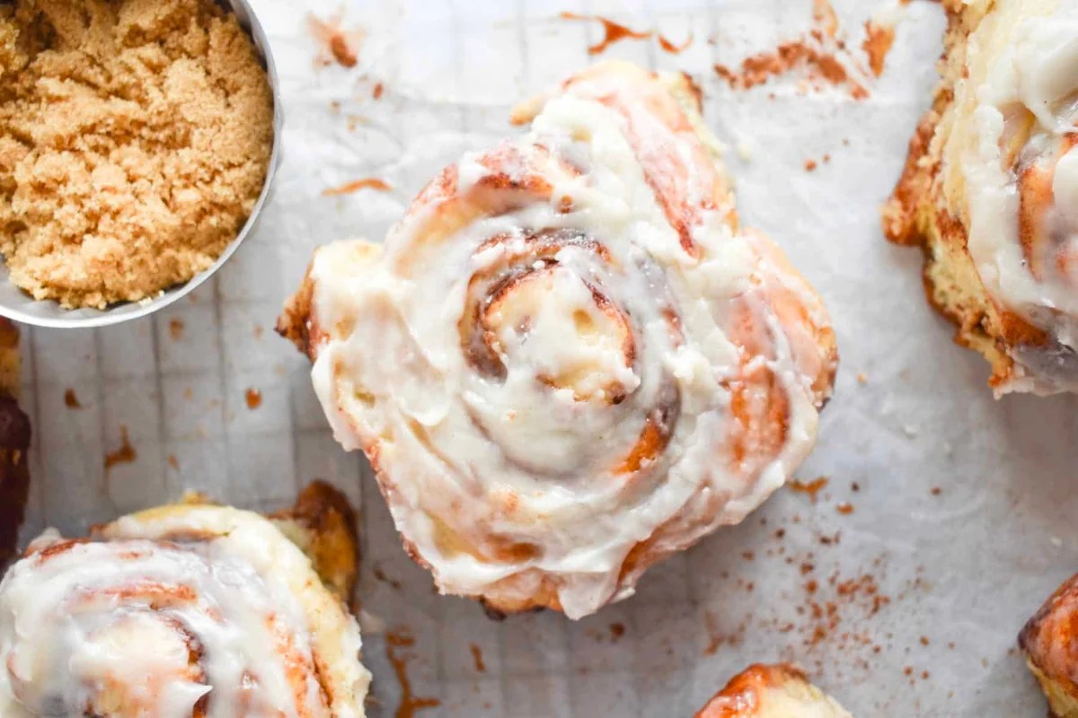 Delicious cinnamon rolls with icing and sugar on a baking sheet, made from scratch using a trusted cinnamon roll recipe.